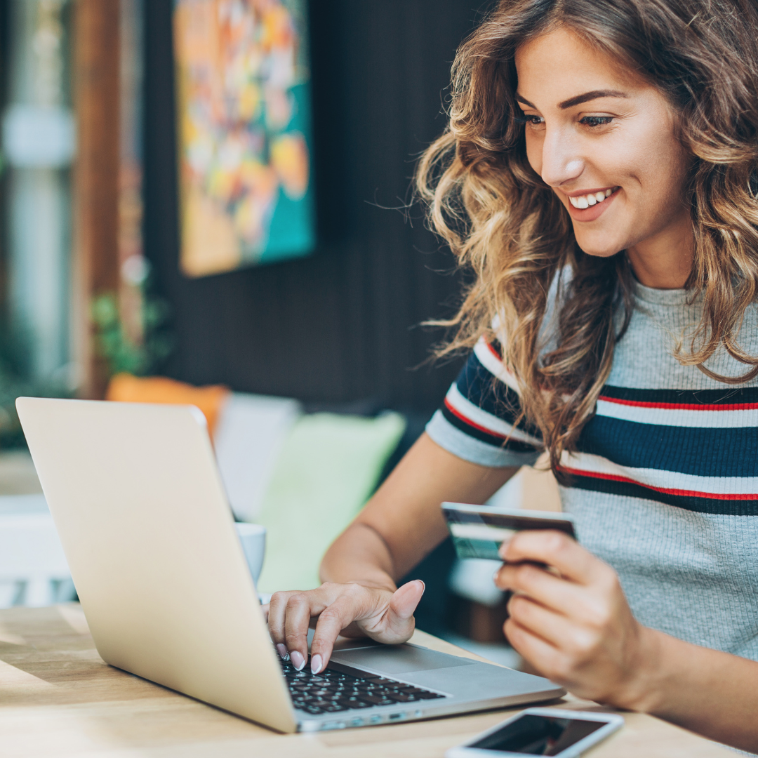 woman on a computer with a credit card making an online order using the Nuvioo system